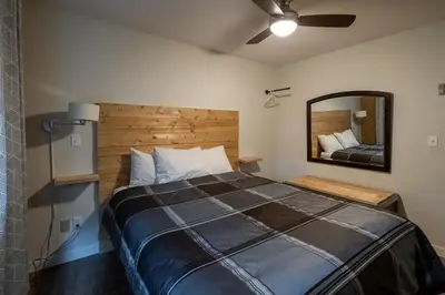 a bedroom with a large bed and a mirror at Rocky Mountain Gem - One Level 750 sq ft - Hot Tub - Quiet Condo - Self Check-In - Free Parking - BBQ Fire Pit Area in Canmore