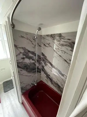 a shower with a red tub in a room at Cabernet Sauvignon Escape in Calgary