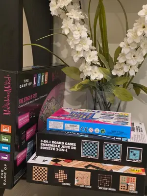 a stack of books sitting next to a vase with flowers at Haven YYC Guest Suite in Northwest Calgary in Calgary