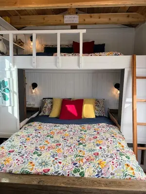 a bed in a bedroom with a bunk bed at Garden Cottage and Bunkie at Horner Park in Victoria