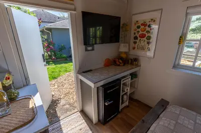 a small kitchen with a stove and a counter at Garden Cottage and Bunkie at Horner Park in Victoria