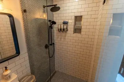 a bathroom with a shower with a glass door at Garden Cottage and Bunkie at Horner Park in Victoria