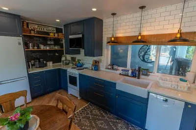 a kitchen with blue cabinets and a sink at Garden Cottage and Bunkie at Horner Park in Victoria