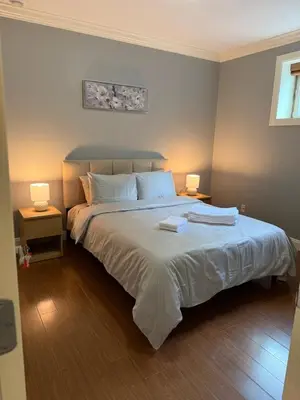 a bedroom with a large bed with two lamps at Peaceful & Cozy Home with 3 rooms, SHARED Bathrooms and SHARED Common Space in Vancouver