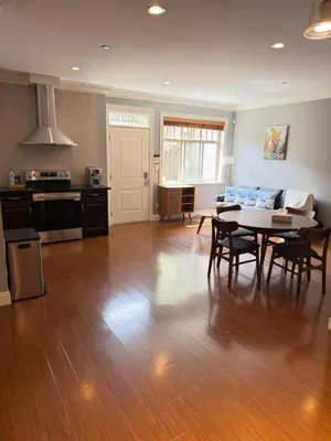 a kitchen and a living room with a table and chairs at Peaceful & Cozy Home with 3 rooms, SHARED Bathrooms and SHARED Common Space in Vancouver