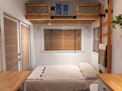 a bedroom with a bed in a room with a window at Riverwood Retreat-hot tub and cedar sauna on the river in Squamish