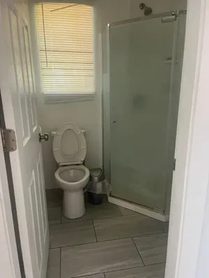 a bathroom with a toilet and a glass shower at three bedroom near uvic in Victoria