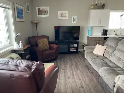 a living room with a couch and a flat screen tv at Heart of Vernon in Vernon