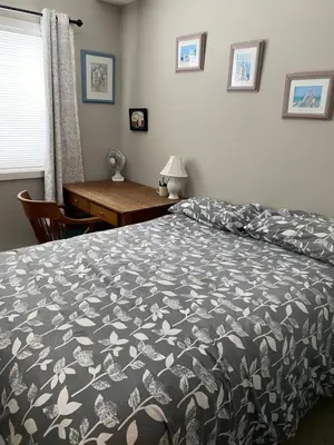 a bedroom with a bed with a black and white bedspread at Heart of Vernon in Vernon