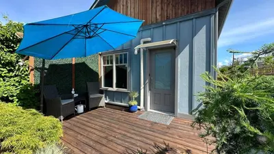 a blue umbrella sitting on top of a wooden deck at Getaway Carriage House - Great Location! Private! in Penticton
