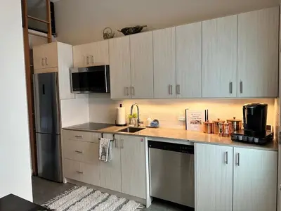 a kitchen with white cabinets and stainless steel appliances at Getaway Carriage House - Great Location! Private! in Penticton