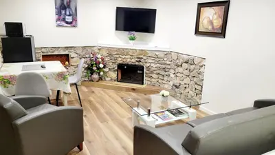 a living room with a stone fireplace and a tv at 4th Street Studio By Downtown and Airport in Calgary