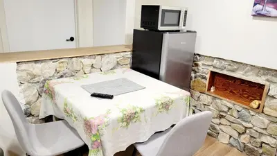 a kitchen with a table with chairs and a refrigerator at 4th Street Studio By Downtown and Airport in Calgary