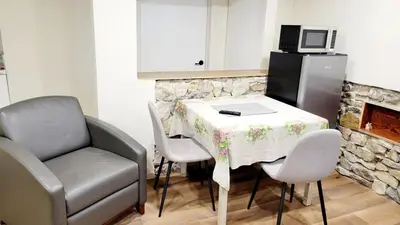 a kitchen with a table and a chair and a microwave at 4th Street Studio By Downtown and Airport in Calgary