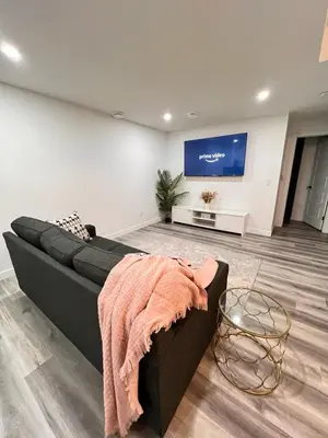 a living room with a couch and a flat screen tv at Cozy Corner - 1 bedroom suite - 15 mins from airport in Calgary