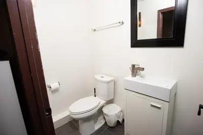 a bathroom with a toilet and a sink and a mirror at Mountain View Retreat in the heart of Banff - Massive House Sleeps 23 in Banff