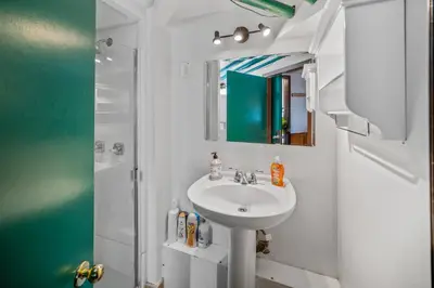 a white bathroom with a sink and a shower at Mountain View Retreat in the heart of Banff - Massive House Sleeps 23 in Banff