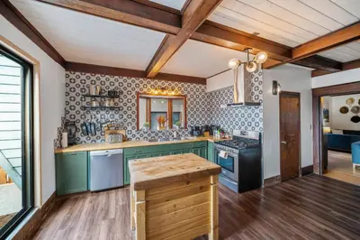 a kitchen with green cabinets and a counter top at Mountain View Retreat in the heart of Banff - Massive House Sleeps 23 in Banff