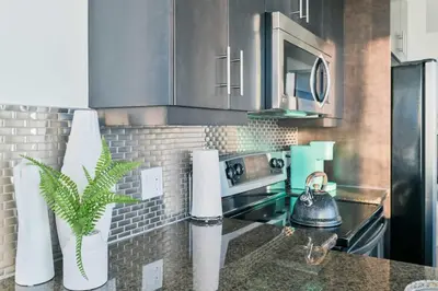 a kitchen with stainless steel appliances and a counter top at City View 2 King Suites Floor-to-Ceiling Views in Calgary