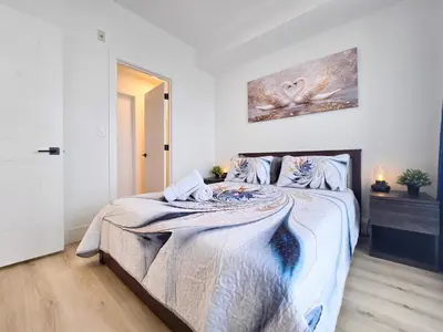 a bedroom with a large bed in a room at Family Stylish 1BR and Den Condo -Apartment with City View, Downtown, Balcony, Free Parking, In-Suite Laundry! in Calgary