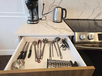 a drawer with knives and other kitchen utensils in it at Family Stylish 1BR and Den Condo -Apartment with City View, Downtown, Balcony, Free Parking, In-Suite Laundry! in Calgary