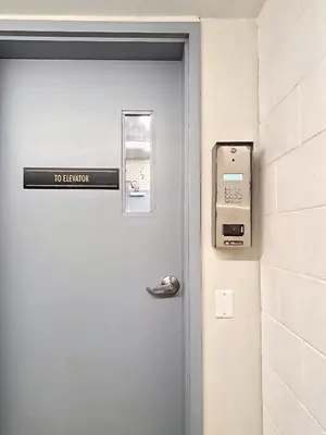 a door with a to elevator sign next to it at Family Stylish 1BR and Den Condo -Apartment with City View, Downtown, Balcony, Free Parking, In-Suite Laundry! in Calgary