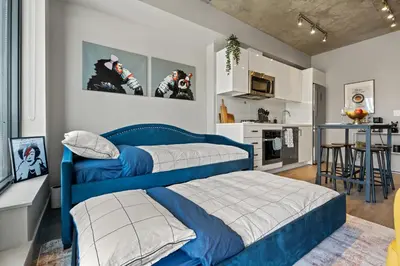 a bedroom with two beds and a kitchen with a table at Vibrant PopArt downtown suite, comfy and stylish! in Calgary