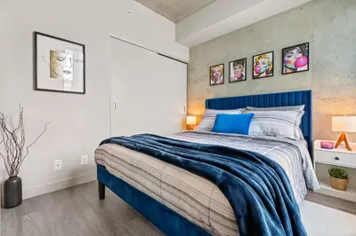 a bedroom with a blue bed in a room at Vibrant PopArt downtown suite, comfy and stylish! in Calgary