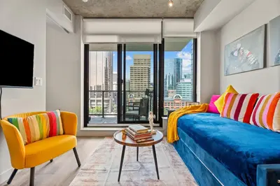 a living room with a blue couch and a table at Vibrant PopArt downtown suite, comfy and stylish! in Calgary