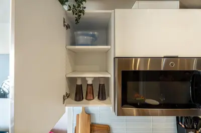 a kitchen with a stainless steel microwave oven at Vibrant PopArt downtown suite, comfy and stylish! in Calgary