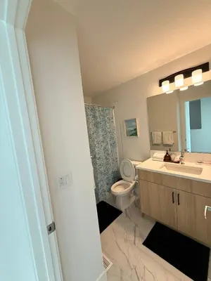 a bathroom with a sink and a toilet and a mirror at IELS Homes in Edmonton
