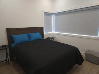 a bedroom with a bed with blue pillows and a window at Urban Elegance: Spacious 2-Bed Townhouse with Modern Charm in Vancouver