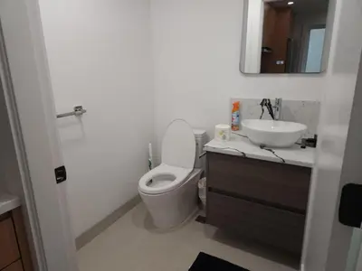 a bathroom with a toilet and a sink and a mirror at Urban Elegance: Spacious 2-Bed Townhouse with Modern Charm in Vancouver