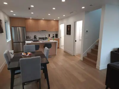 a kitchen and living room with a table and chairs at Urban Elegance: Spacious 2-Bed Townhouse with Modern Charm in Vancouver