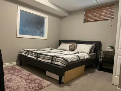 a bedroom with a bed in a room with a window at Rooms for Hosting in Calgary