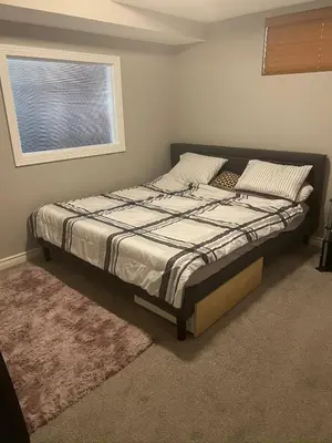 a bed in a bedroom with a window at Rooms for Hosting in Calgary