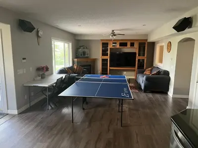 a living room with a ping pong table in it at Rooms for Hosting in Calgary