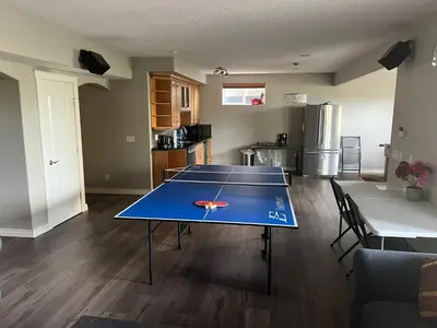 a living room with a ping pong table in it at Rooms for Hosting in Calgary