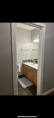 a bathroom with a sink and a large mirror at Rooms for Hosting in Calgary