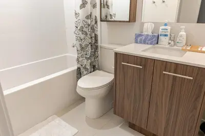 a bathroom with a toilet and a sink and a tub at Scenic 2BR RiverView Suite in Downtown in Calgary