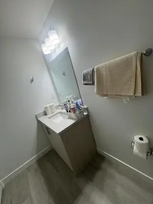 a bathroom with a sink and a mirror at Cozy Inn new basemt wt sep entrance contains 1 bdrm and den for up to 4 guests in Airdrie