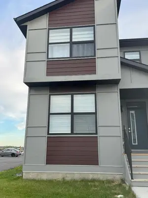 a house with a brown and white at Cozy Inn new basemt wt sep entrance contains 1 bdrm and den for up to 4 guests in Airdrie