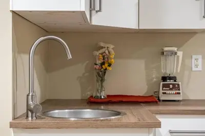 a kitchen counter with a sink and a vase of flowers at Private & Beautifully Finished Suite, Windermere in Edmonton