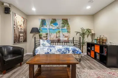 a bedroom with a bed and a chair and a table at Private & Beautifully Finished Suite, Windermere in Edmonton