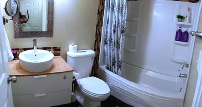 a bathroom with a toilet and a sink and a shower at Beautifully Finished Basement Suite, Shared Entrance, SW Edmonton in Edmonton