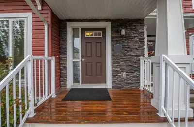 a front door of a house with a staircase at Beautifully Finished Basement Suite, Shared Entrance, SW Edmonton in Edmonton