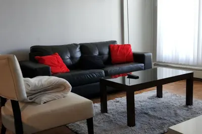 a living room with a black couch and a coffee table at Elevated Living: 2-Bedroom Upper Apartment in Calgary