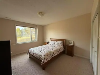 a bedroom with a bed and a window at Spacious mountain view guesthouse in Calgary
