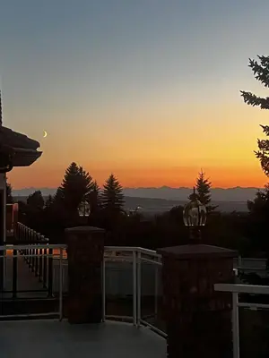 a sunset from the deck of a house at Spacious mountain view guesthouse in Calgary