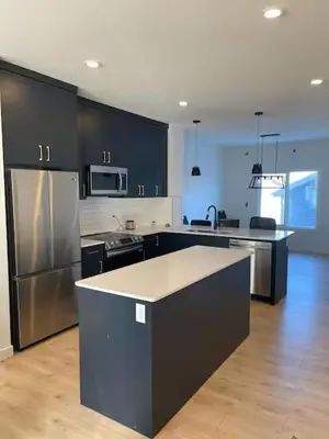 a kitchen with black cabinets and stainless steel appliances at Bedroom private Bathroom in Upland in Edmonton